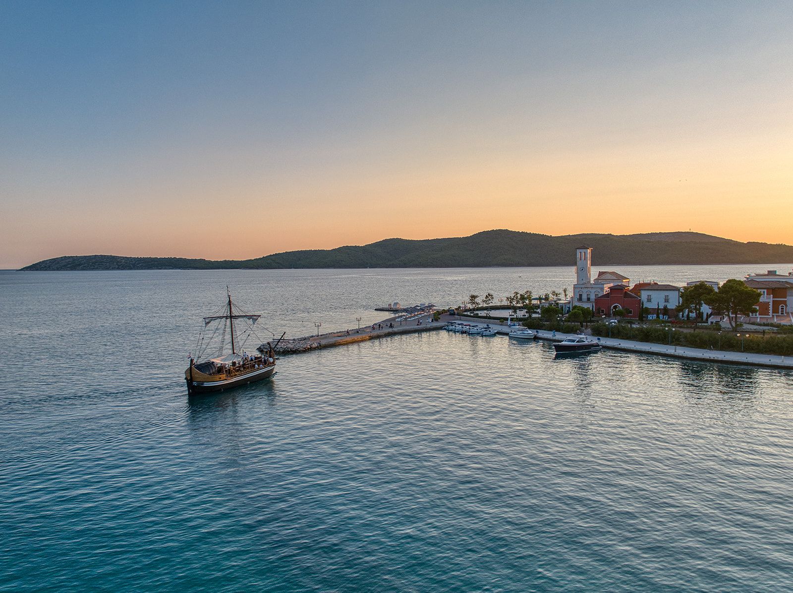 Amadria Park marina at sunset with traditional Croatian sailing boat and resort buildings, Šibenik
