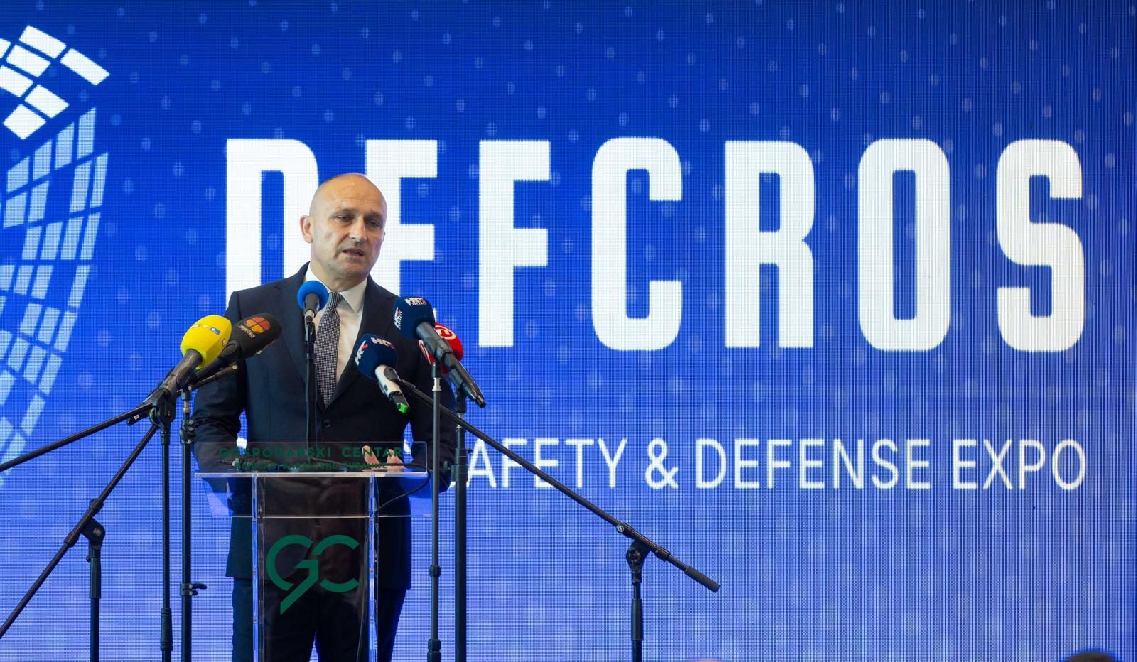 DEFCROS 2 opening ceremony — keynote speaker addresses the audience from the main stage in front of the DEFCROS LED wall