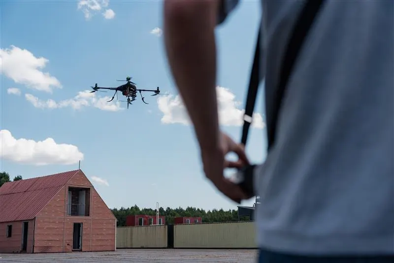 A pilot flying a drone over the training grounds