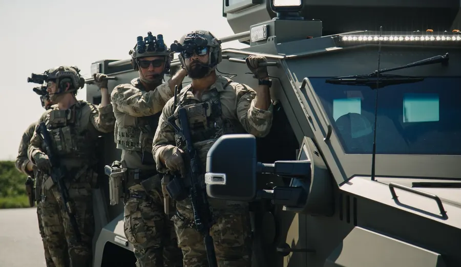 A tactical team moving alongside an armoured vehicle
