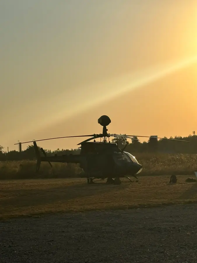 Military helicopter silhouetted against the sunset on the outdoor display ground