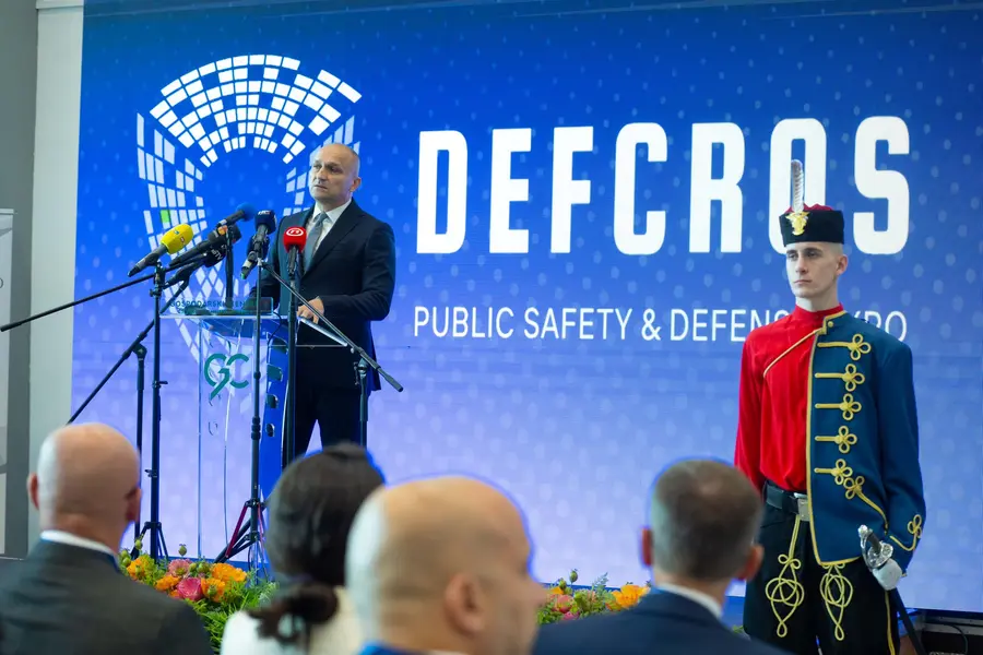 Keynote at the DEFCROS podium beside an honour guard in historical uniform