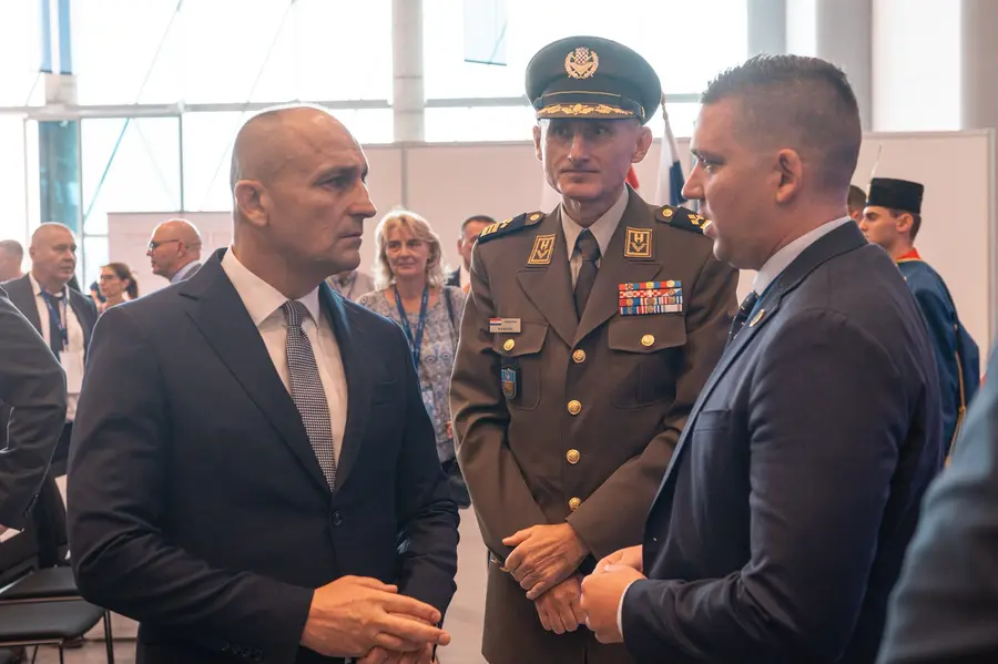 Officials and a senior army officer in conversation in the exhibition hall