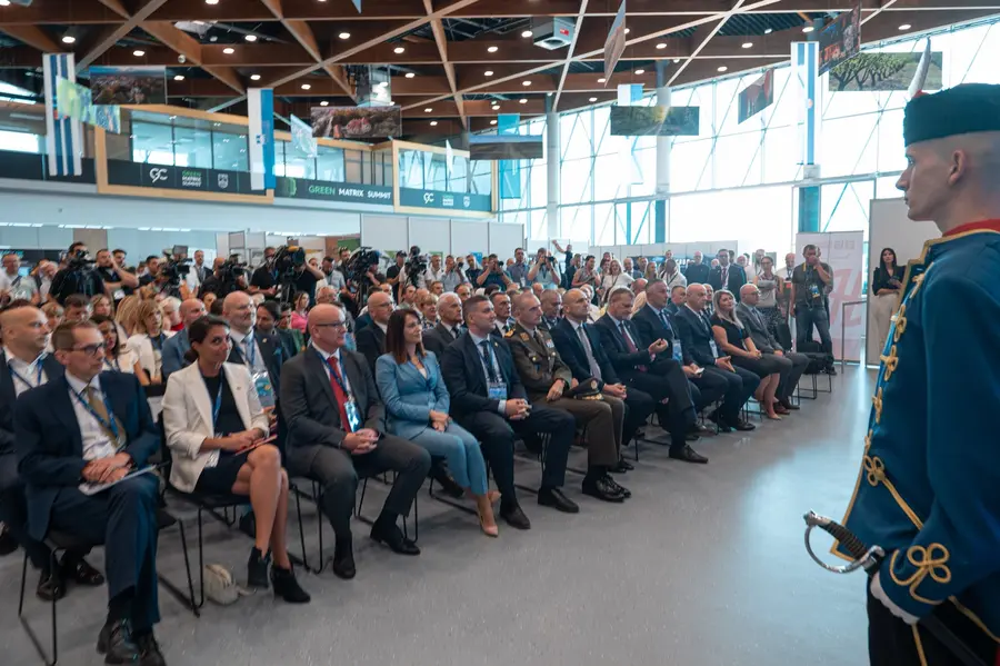 Packed audience at the opening ceremony, with an honour guard in historical uniform