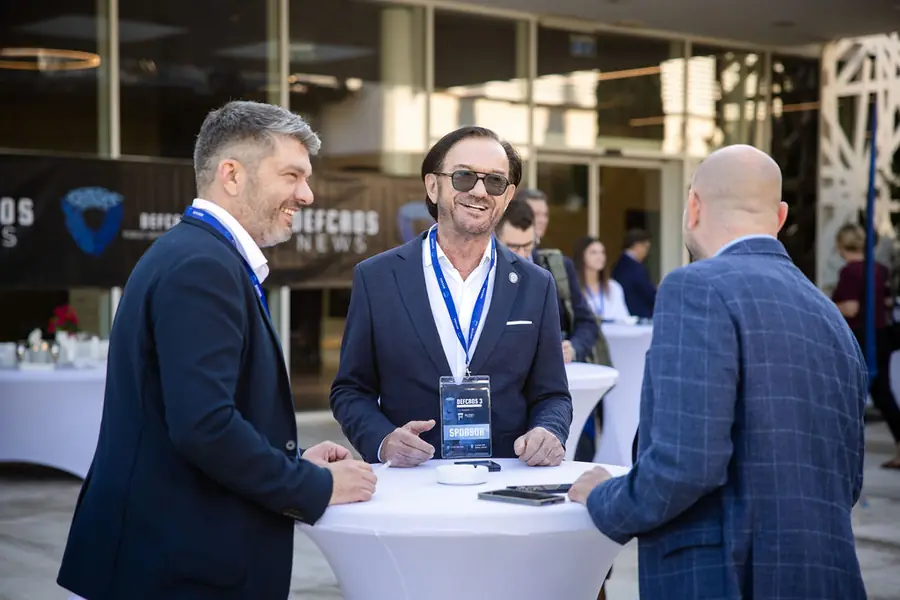 Delegates networking at a high table on the exhibition floor